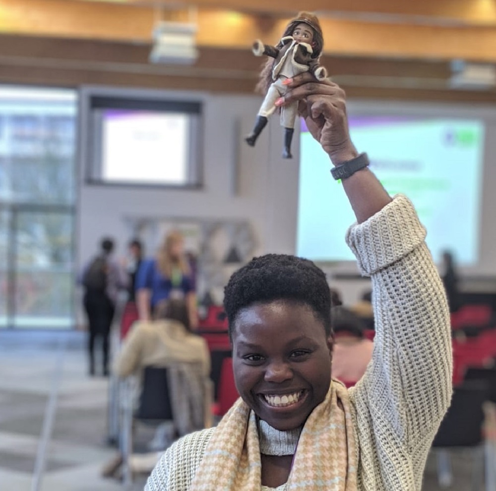 Seyi holding a female pilot figurine above her head. 